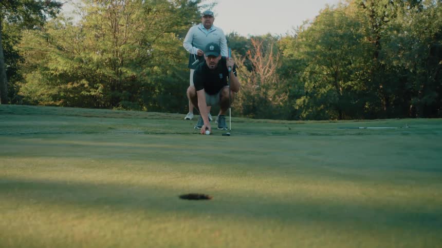 Man positioning golf ball straight toward the target