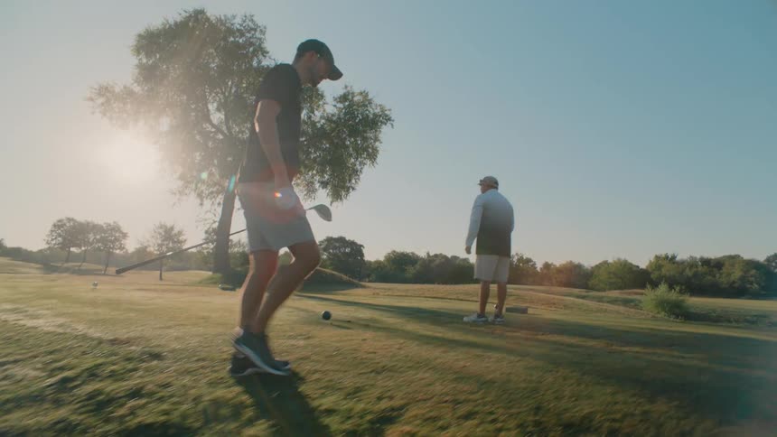 The golf players walk up the hill