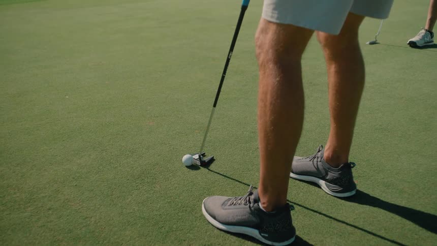 The man puts the golf ball