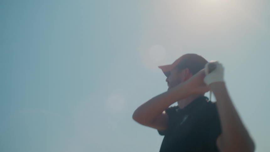 Two men teeing off on a golf course