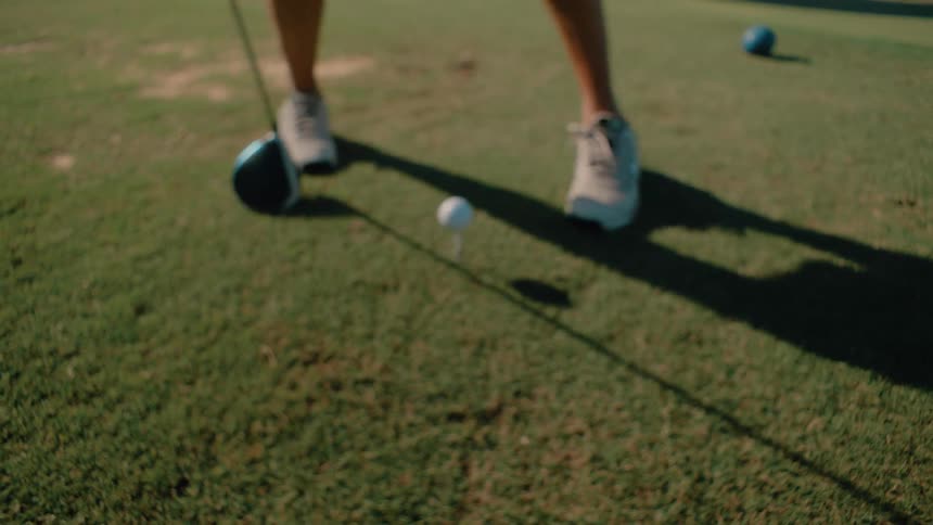 Player wearing a glove positions a golf ball on a field