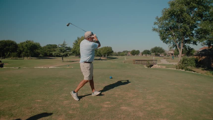 Golfer throws the ball forcefully across the field