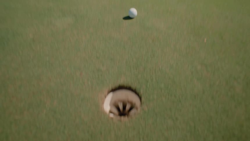 Person takes a golf swing and the ball hits the target