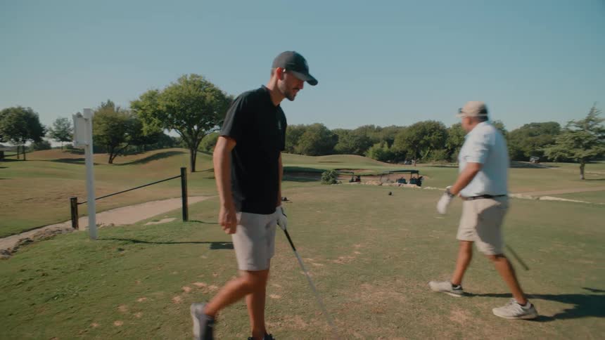 The golf player walks over to the ball