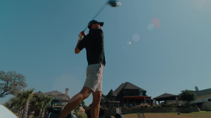 The man is playing golf near the golf club