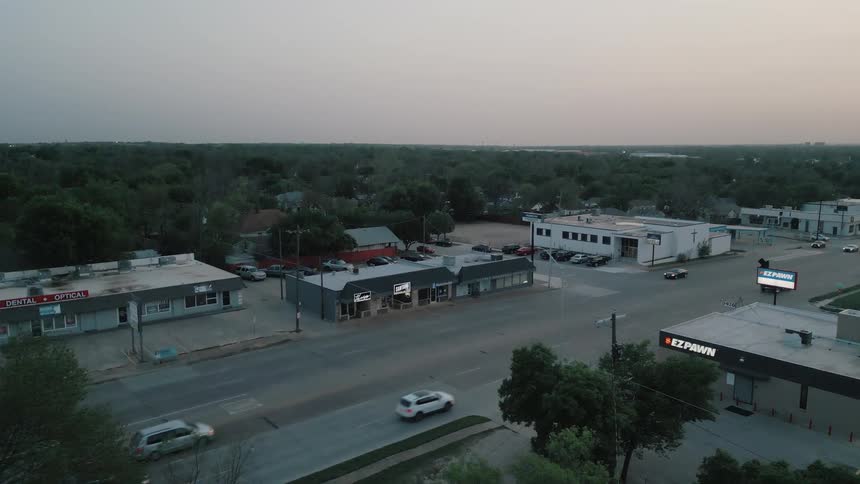 Businesses and buildings along the road as traffic passes by them