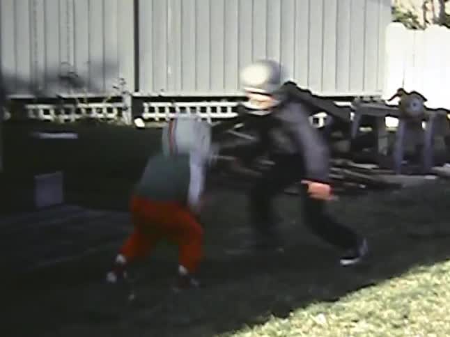 Kids play with a football in a residential backyard on an autumn day