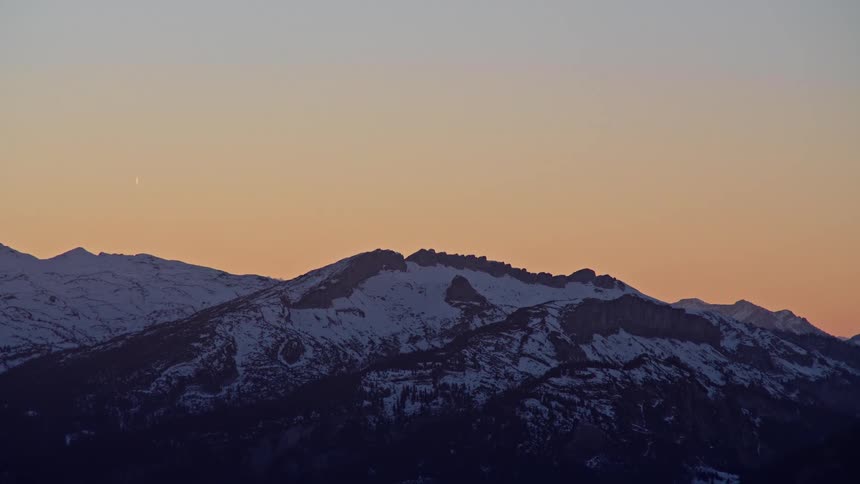 A snowcovered mountain at sunset
