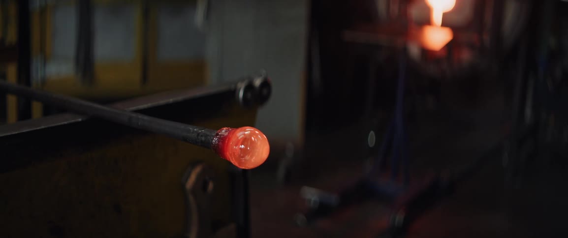 Glass being rolled out on a metal workshop table