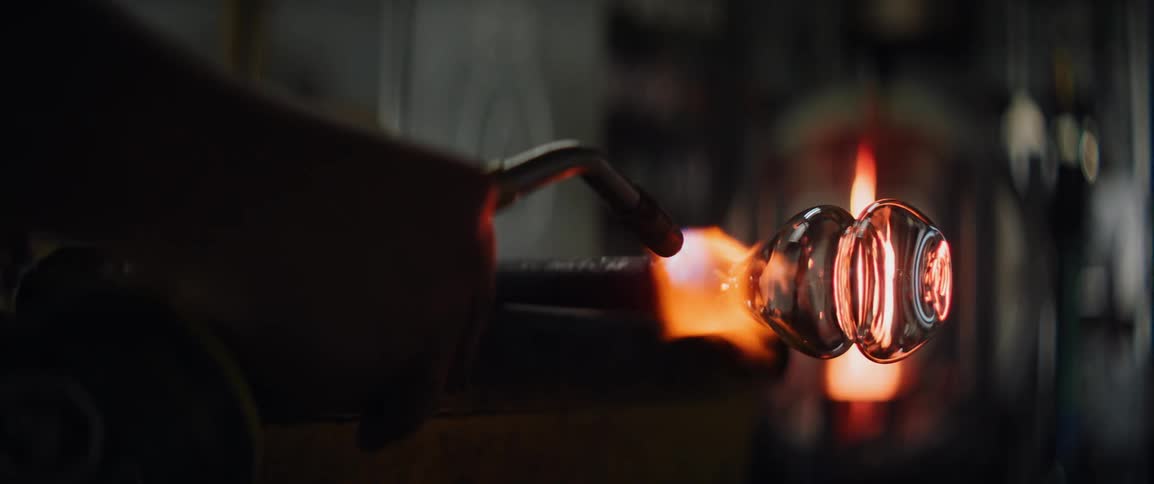 A person working on a piece of glass with a torch
