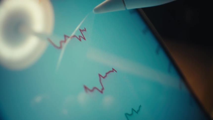 Screen with red waveforms and stylus interacting with biometric data
