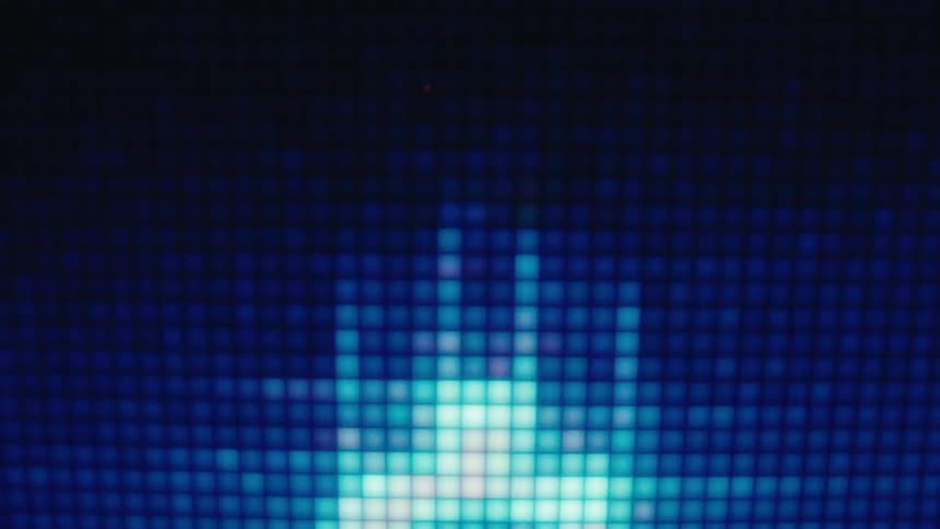 A closeup video shows a pixelated crt screen displaying retrostyle digital graphics including scrolling dollar signs and abstract shapes that glow with vibrant colors against a dark gridpatterned background