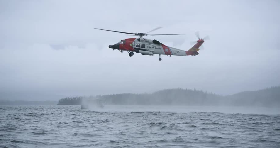 Coast guard helicopter flying low over the sea during a rescue operation