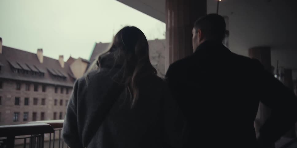A man and woman along a path located next to a brick building