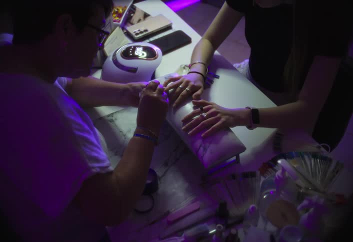 A woman working on a manicure for another woman