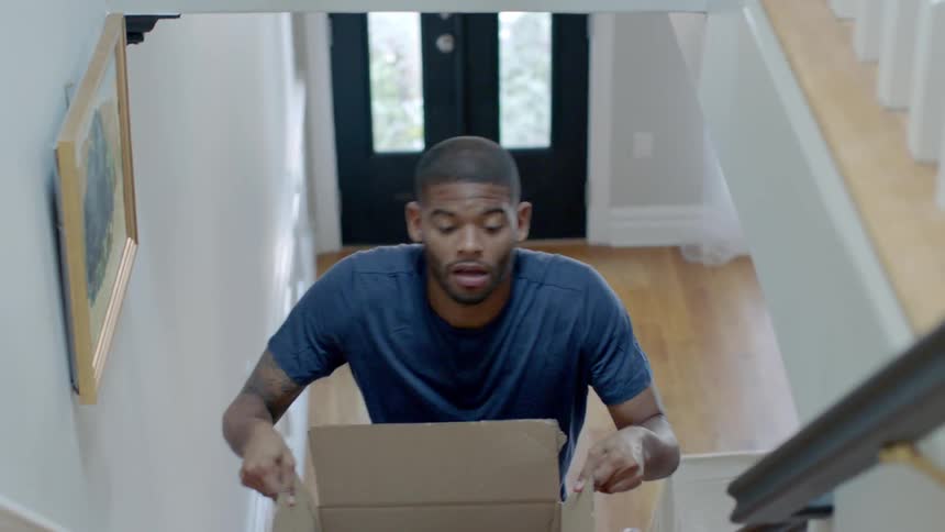 A man carries a box up the stairs