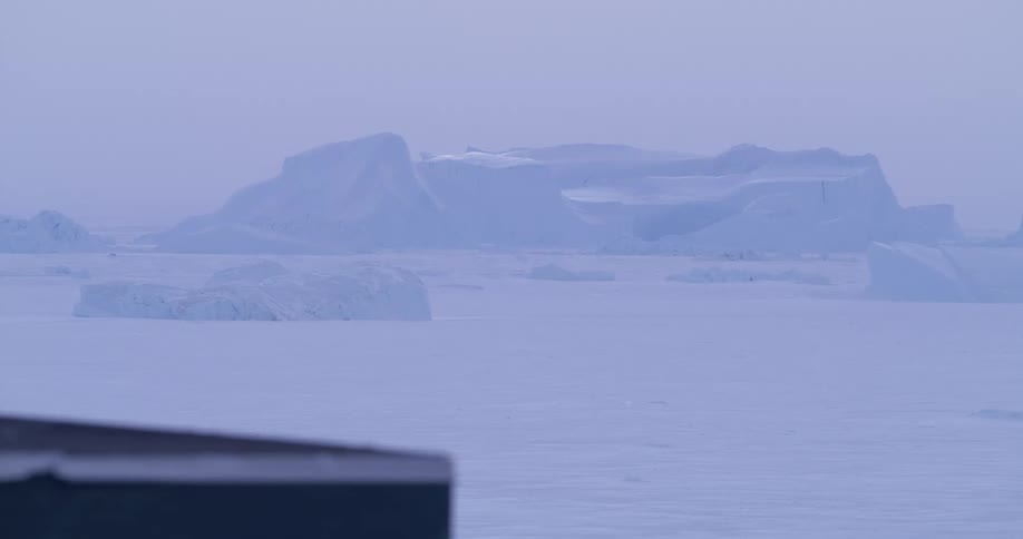 Iceberg in the background over a frozen surface in a polar environment