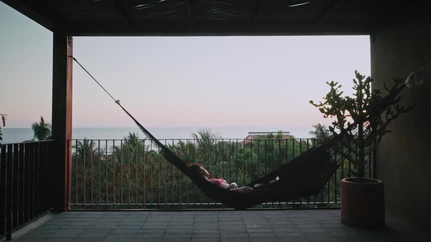 Woman swinging in a hammock on her patio
