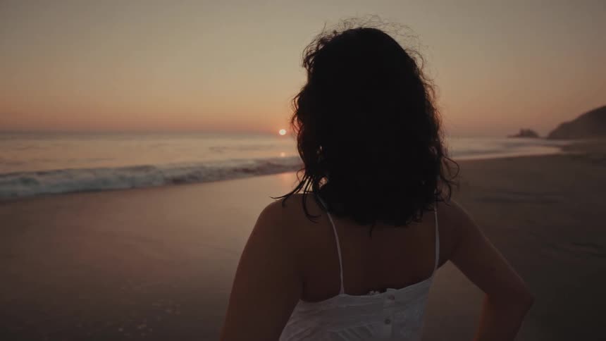 A woman watching the sunset on the beach