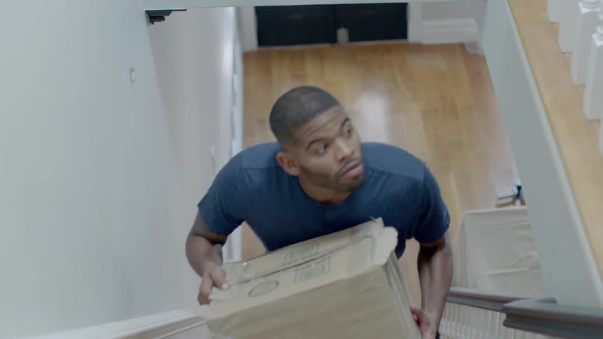 Man carries a box upstairs