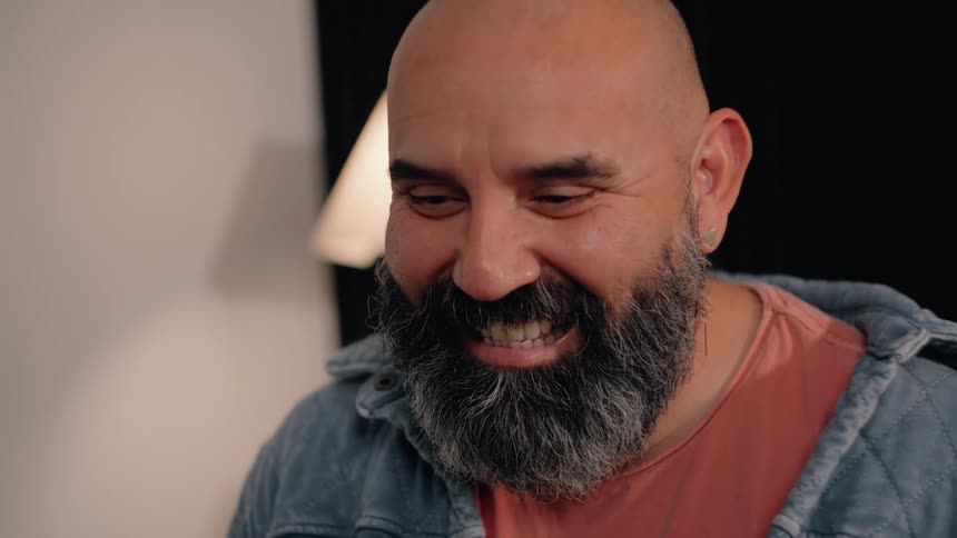 Bald bearded man smiling in an indoor setting