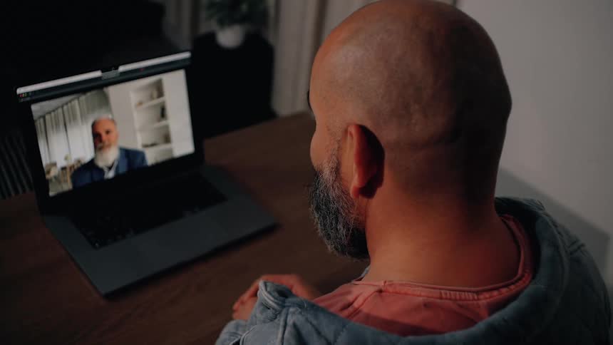 A man sitting and looking at a computer screen