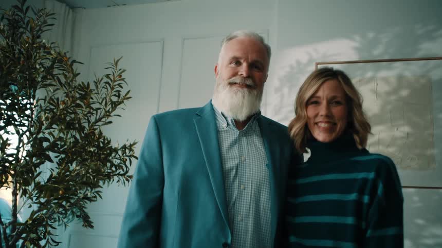 Couple standing and smiling in a naturally lit indoor setting