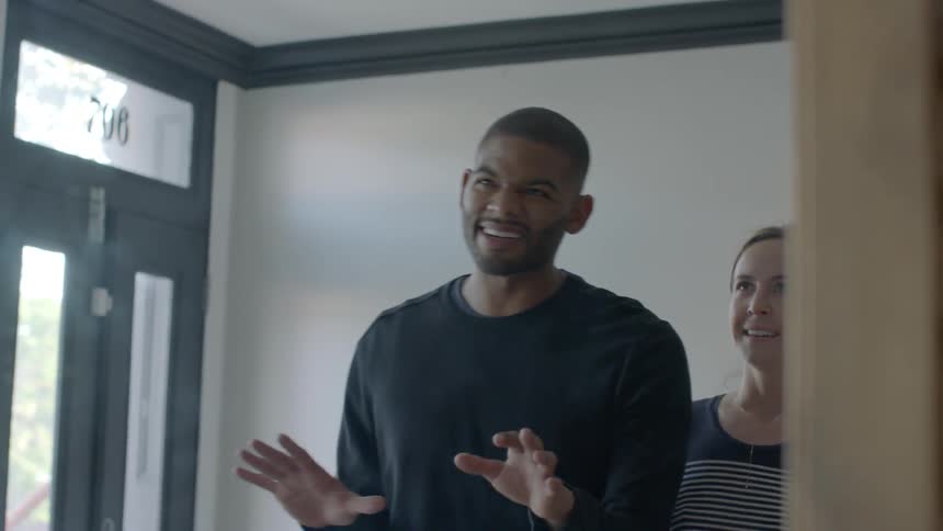 A man and woman talk in front of a mirror