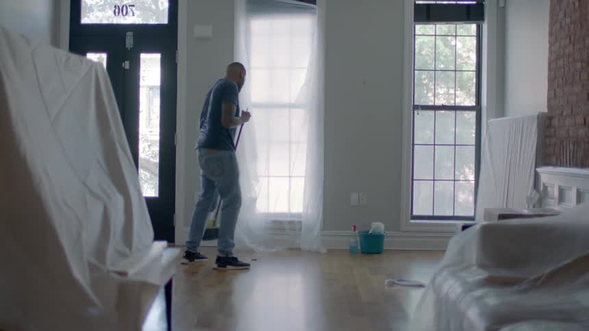 A man sweeps a wood floor
