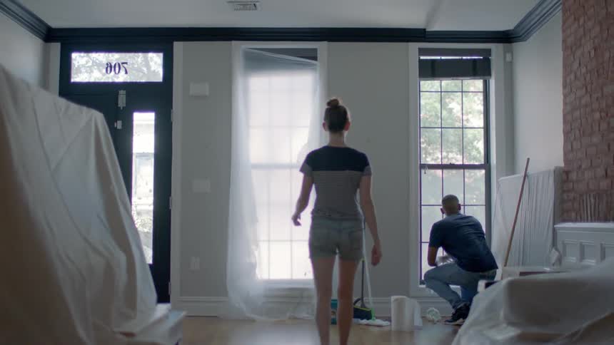 Two people are cleaning up a living room