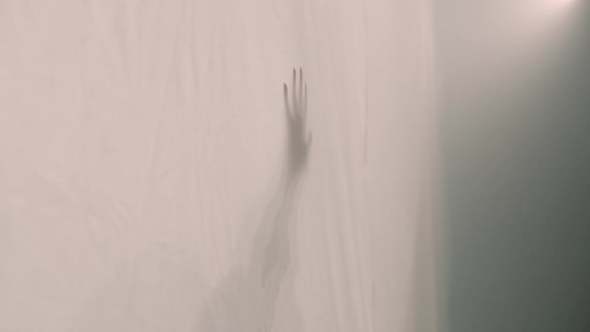 A hand up against an opaque sheet