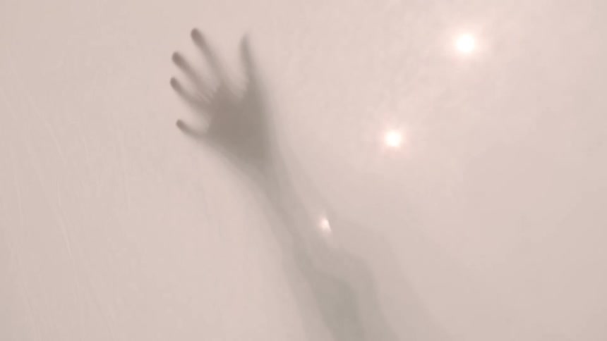 Hand silhouette behind a translucent curtain illuminated by diffused light