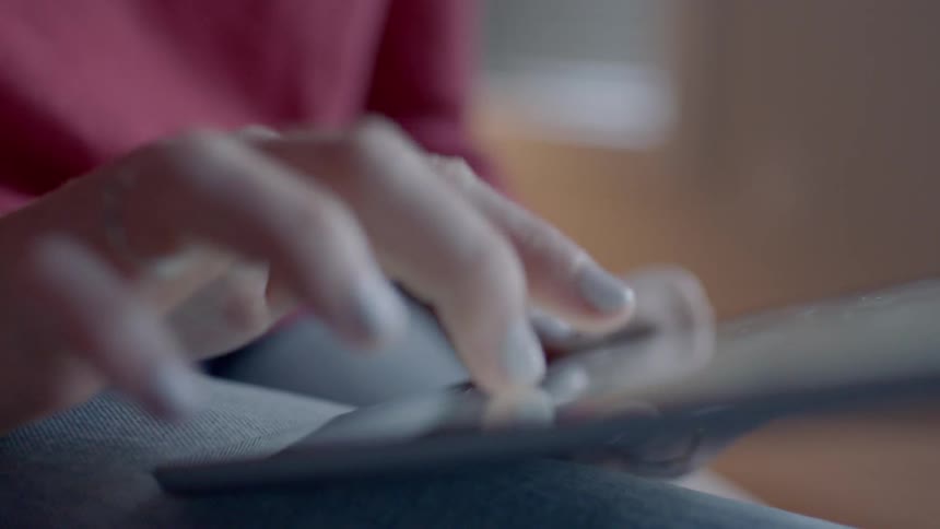 A woman types on a tablet