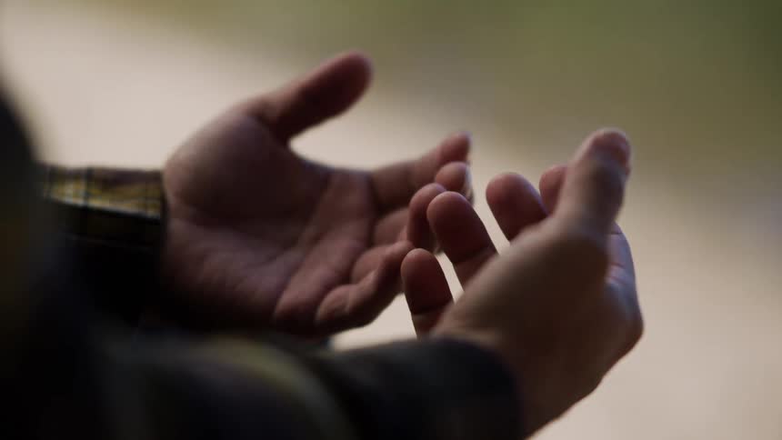 A close up shot shows a person looking at their empty hands with palms turned upward