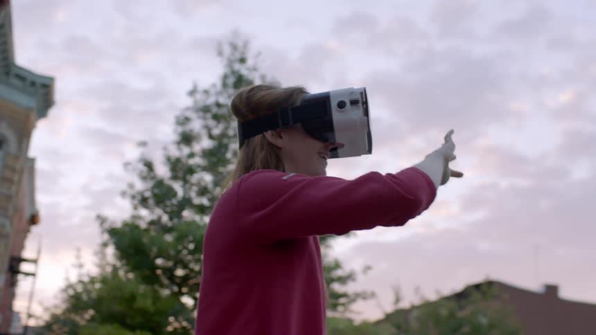 A woman wearing a vr mask pages and scrolls with her hand in the air