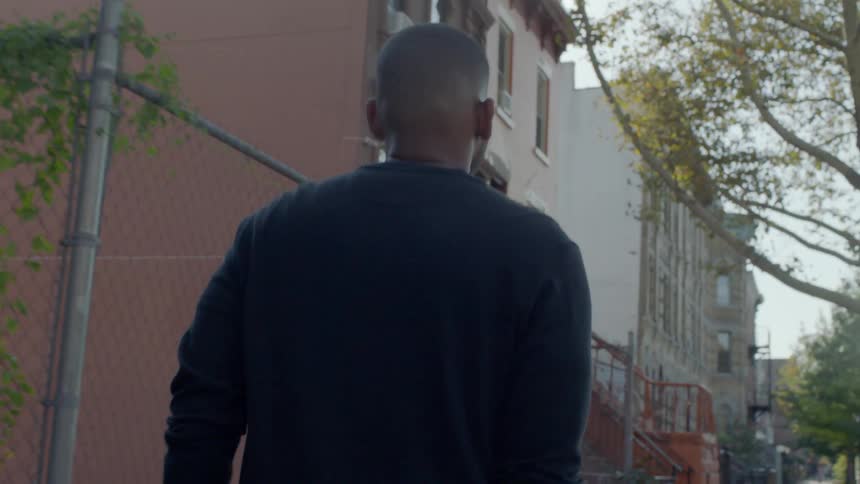 A man walks down a city sidewalk
