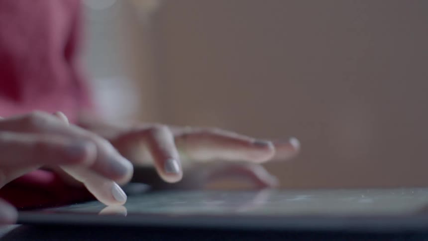 Woman typing on an electronic tablet device