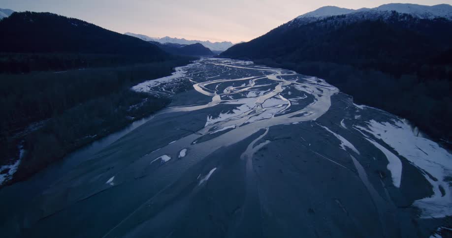 An aerial view of a river with mountains in the distance
