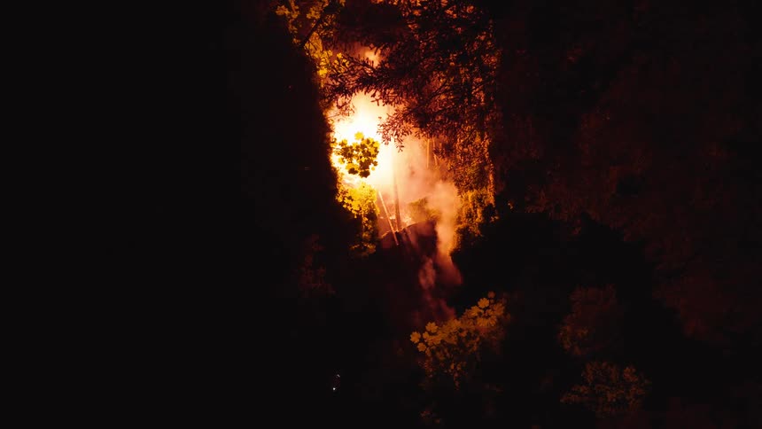 A fireball shoots through the forest at night