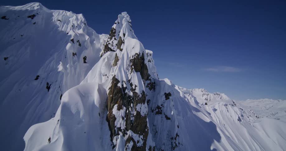 Steep snowcovered peaks under a clear blue sky