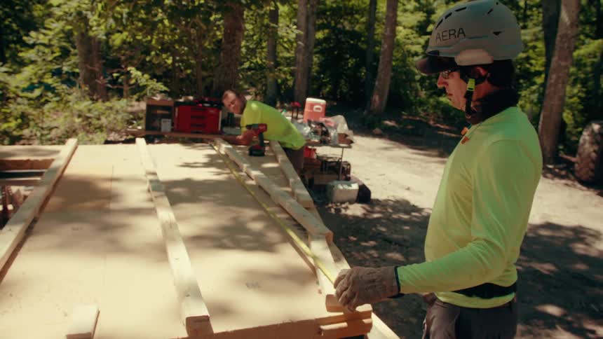 Two men measuring materials outdoors