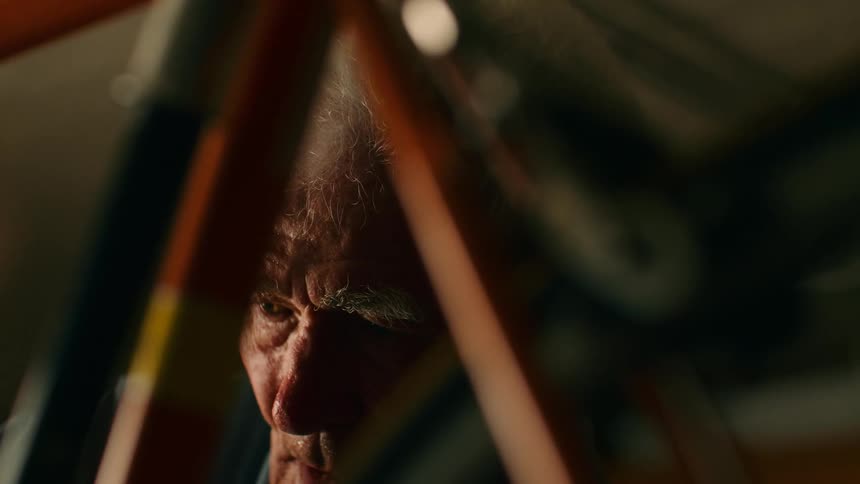 Elderly face partially obscured by bicycle