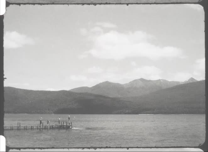 People jumping into the sea from a wooden pier