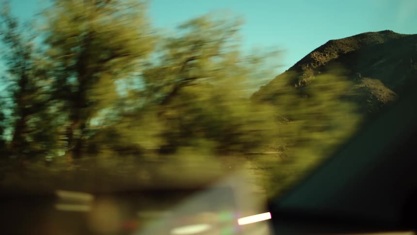 The car drives by the green mountains
