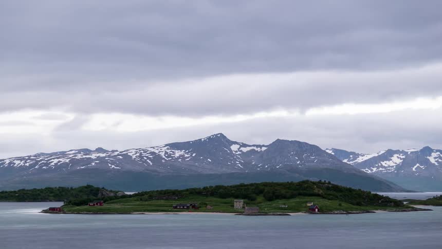 The clouds move fast over the snow covered mountain ahead