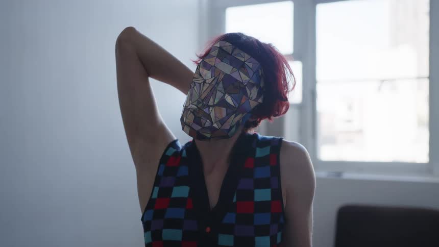 A woman wearing a mask made of mirrored metal