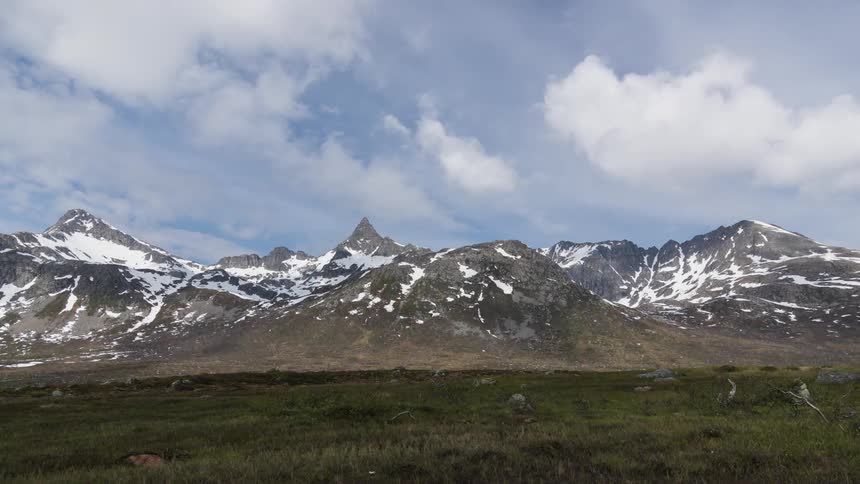 Clouds draw shadows on snowy mountain range