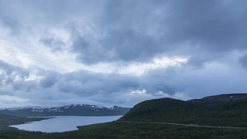 Clouds pass over a scenic mountain lake