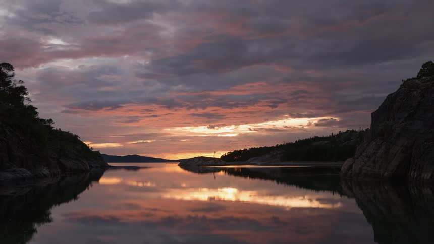 Clouds rolling over a river at sunset