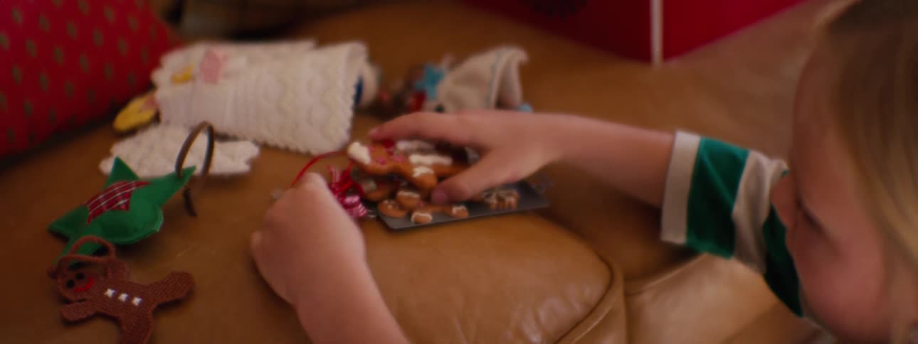 Little girl playing with gingerbread men christmas decorations